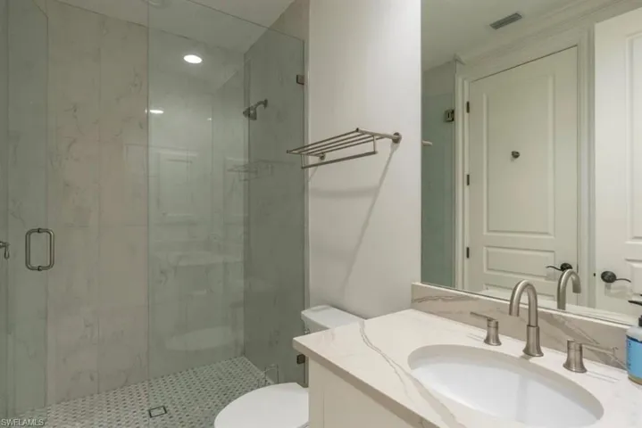 Full bathroom with vanity and a marble finish shower