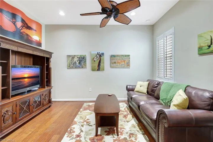Living area with ceiling fan, light wood-style flooring, and recessed lighting