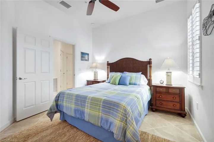 Bedroom with ceiling fan and light tile patterned flooring