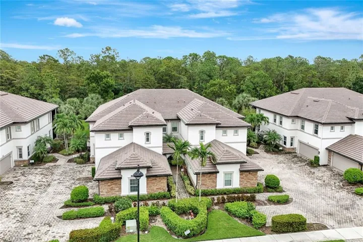 View of front of property with decorative driveway, stucco siding, and stone siding