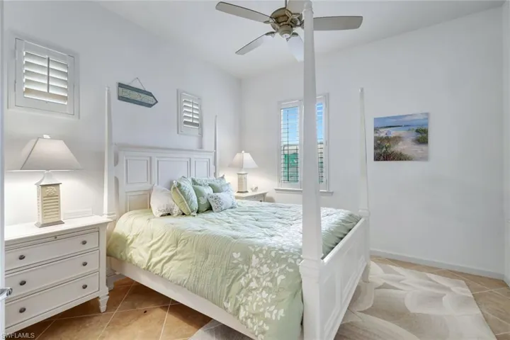 Bedroom with light tile patterned floors and ceiling fan