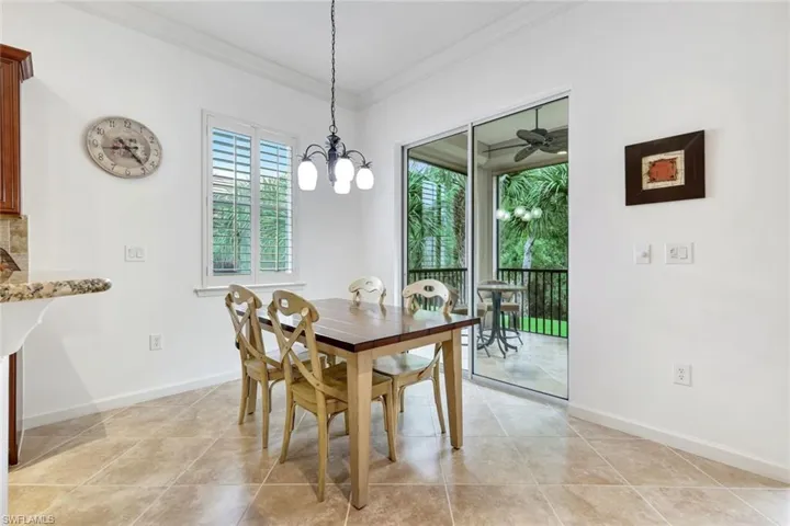 Dining room with healthy amount of natural light, ornamental molding, a chandelier, and light tile patterned floors
