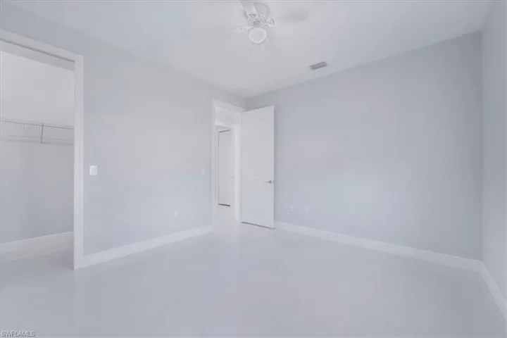 Unfurnished bedroom featuring a spacious closet and a ceiling fan