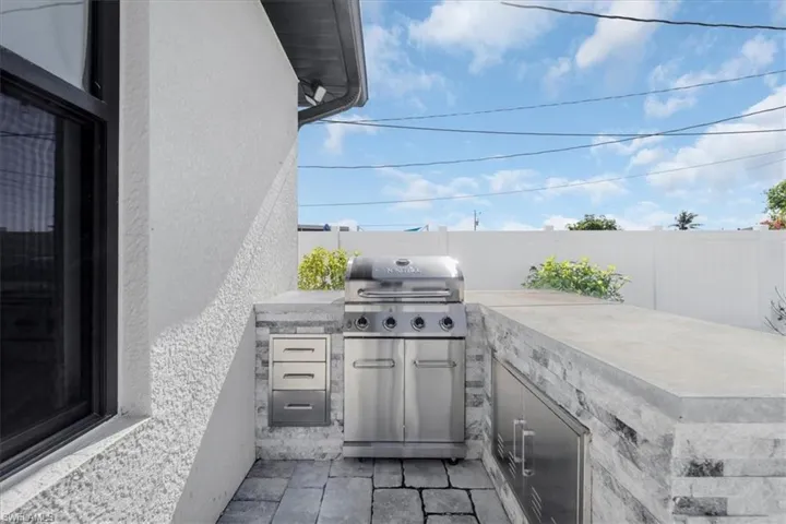 Fenced backyard featuring area for grilling and a patio