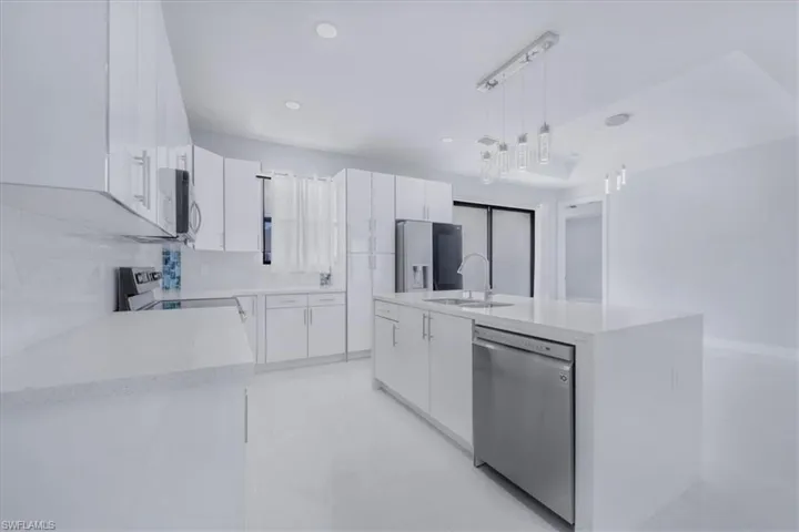 Kitchen with white cabinets, decorative light fixtures, appliances with stainless steel finishes, modern cabinets, and recessed lighting