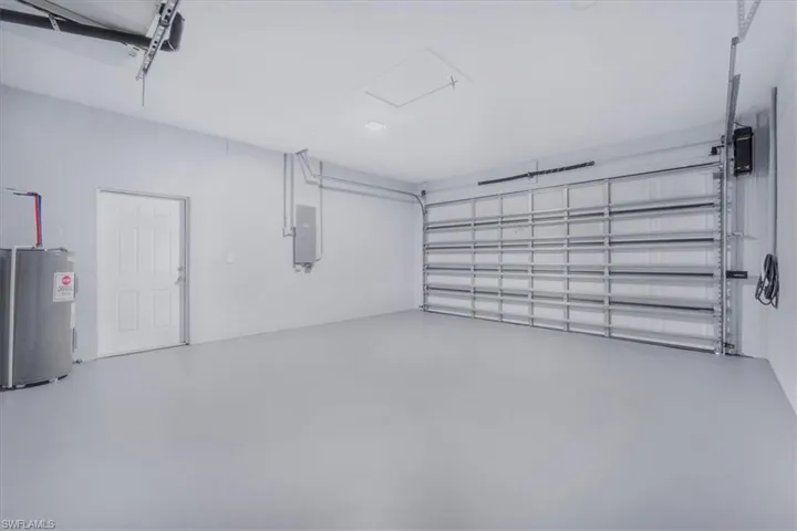 Garage featuring electric water heater and electric panel