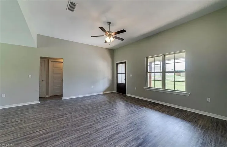 Spare room featuring dark wood-style flooring and ceiling fan
