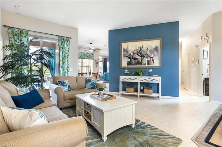 Living room with light tile patterned floors and ceiling fan