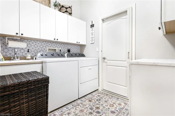 Washroom with washer and clothes dryer, cabinets, and light tile patterned floors