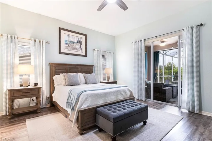 Bedroom with wood-type flooring, access to outside, and ceiling fan