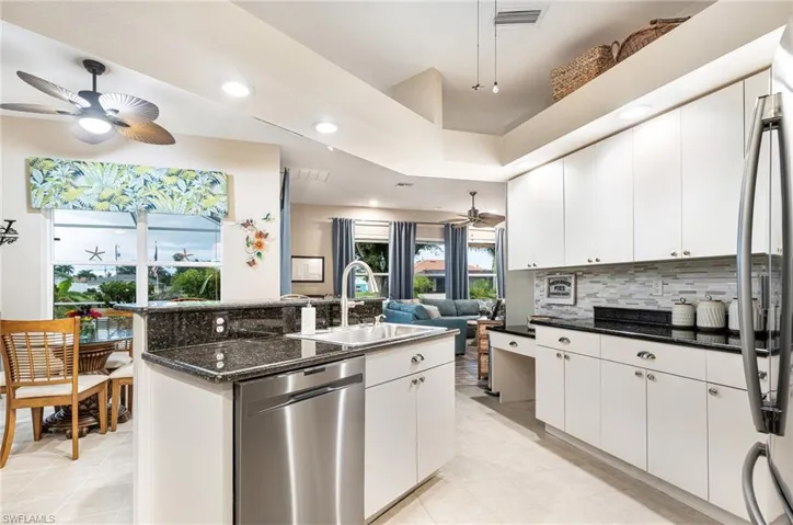 Kitchen featuring white cabinetry, ceiling fan, stainless steel appliances, and light tile patterned floors