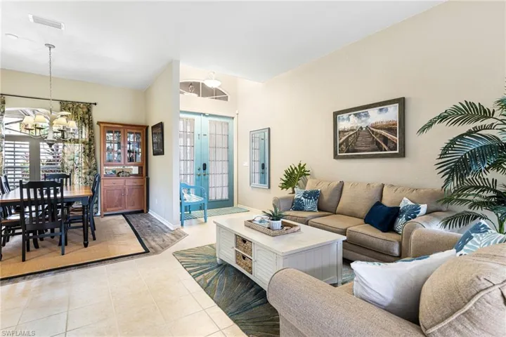 Living room featuring an inviting chandelier, french doors, and light tile patterned floors