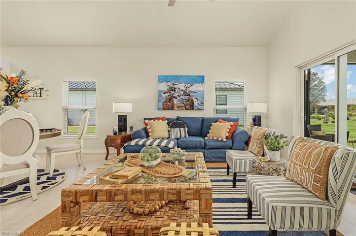Living room featuring light tile patterned floors, ceiling fan, and plenty of natural light