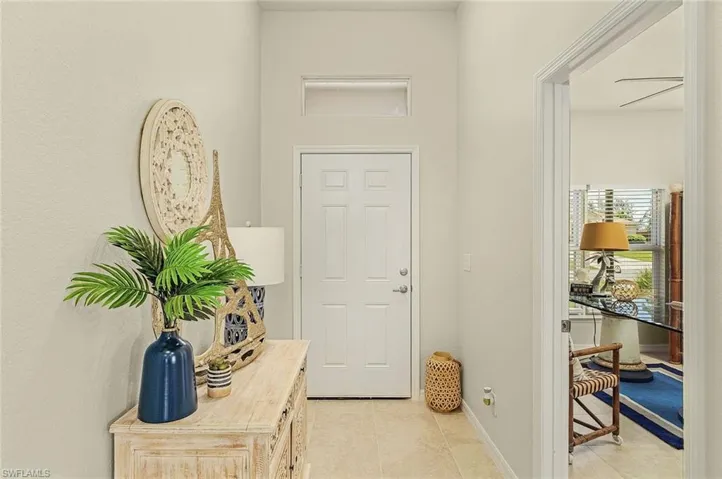 Foyer entrance featuring light tile patterned floors and baseboards