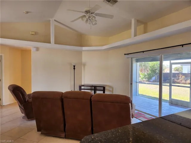 Living area with a ceiling fan and decorative shelving.
