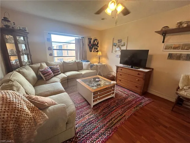Living room with dark wood-type flooring and ceiling fan