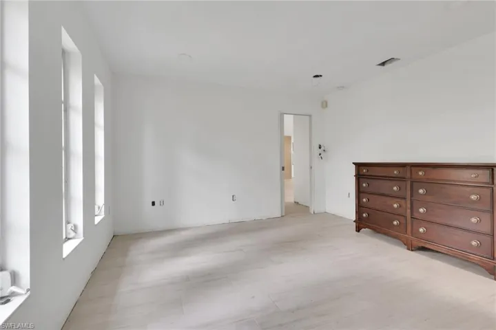 Bright, spacious room with light wood-finish flooring