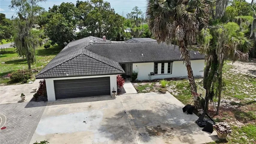 Single-story residence featuring a dark tile roof and a white exterior