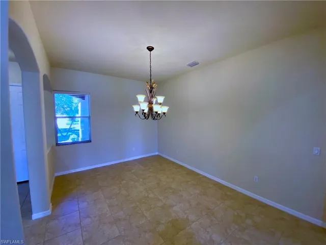 Unfurnished room featuring a chandelier and arched walkways