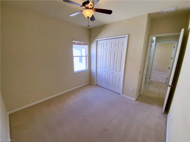 Unfurnished bedroom with carpet floors, a closet, and ceiling fan