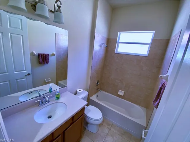 Full bathroom with vanity, shower / bathtub combination, and light tile patterned floors