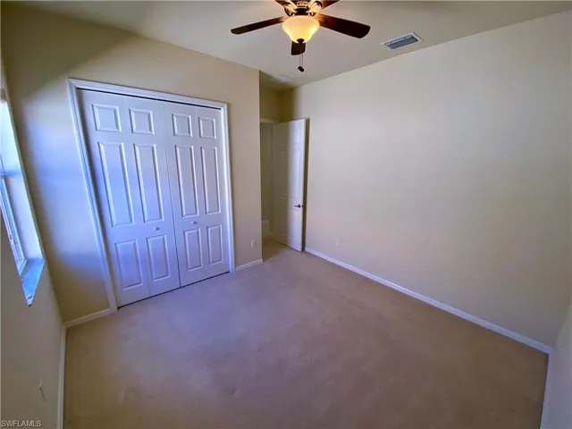 Unfurnished bedroom with carpet flooring, a closet, and ceiling fan