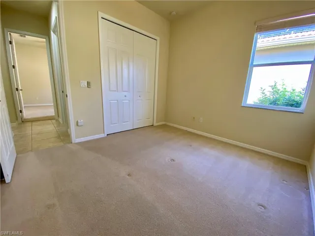 Unfurnished bedroom featuring light colored carpet and a closet