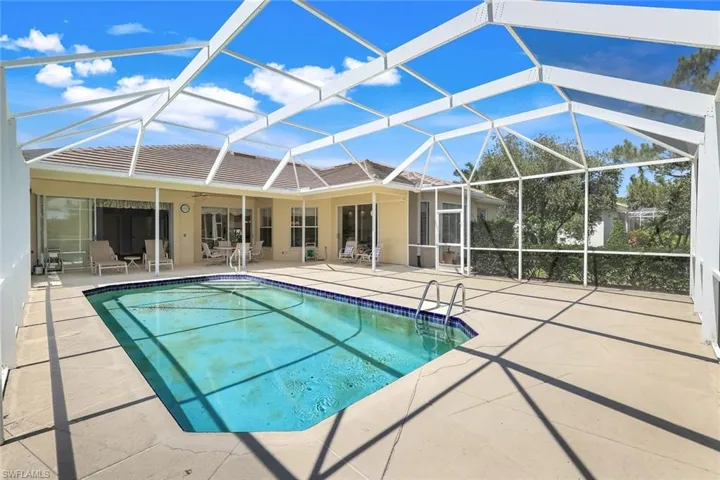 Swimming pool with a patio, a ceiling fan, and glass enclosure