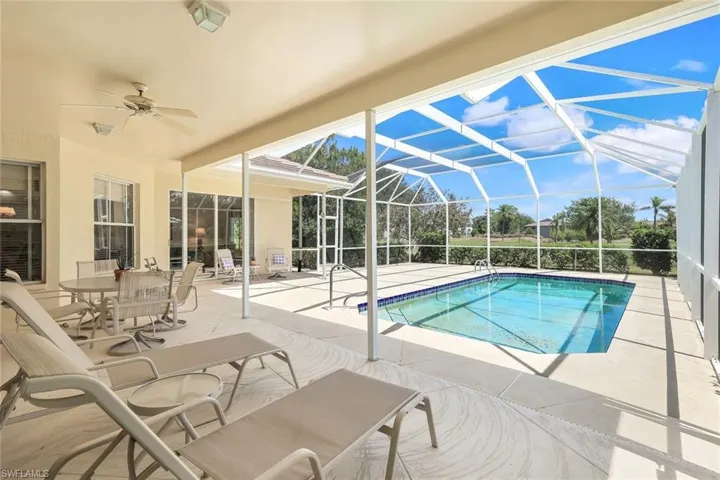 Outdoor pool with a patio area, a ceiling fan, and a lanai