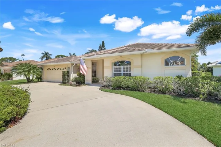 View of front facade featuring concrete driveway, stucco siding, a tile roof, and a garage
