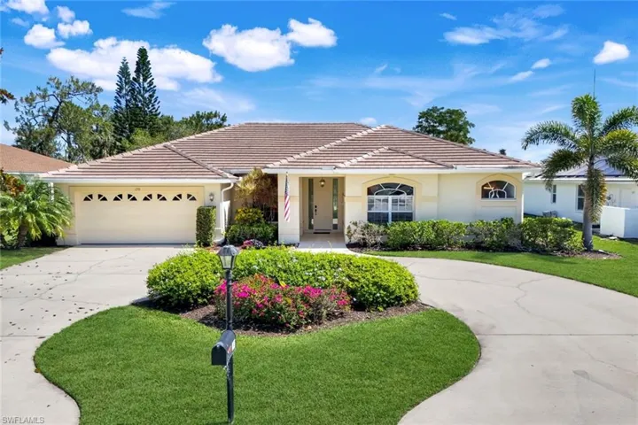 View of front of house featuring concrete driveway, a tiled roof, stucco siding, and a front lawn