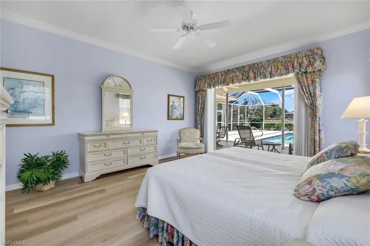 Bedroom featuring access to outside, crown molding, light wood-type flooring, baseboards, and a ceiling fan