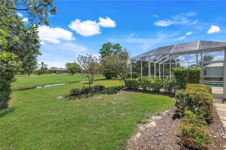View of green lawn featuring glass enclosure