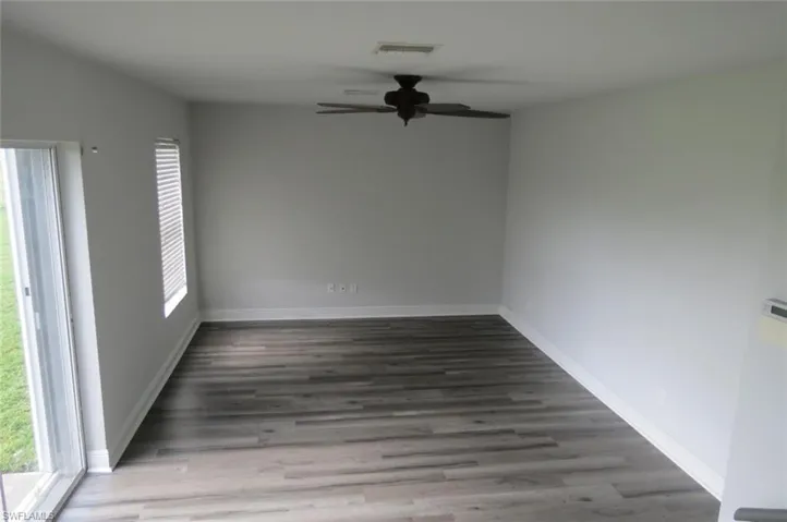 Unfurnished room featuring dark hardwood / wood-style flooring and ceiling fan