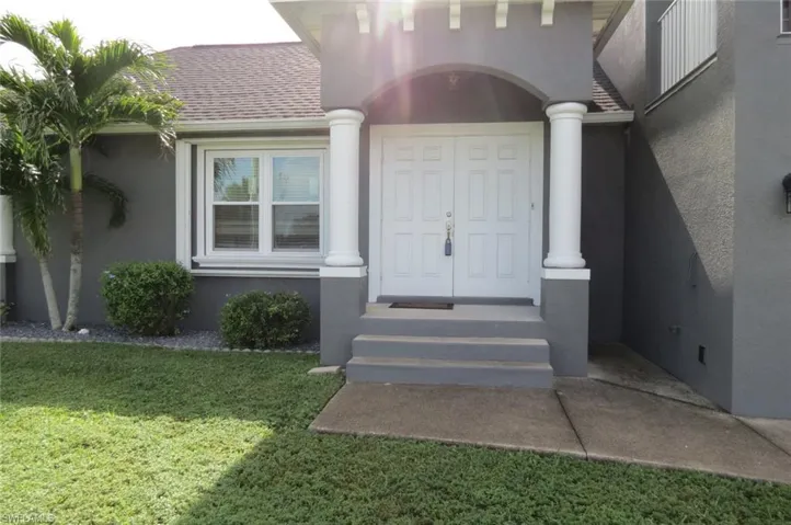 View of exterior entry with a yard