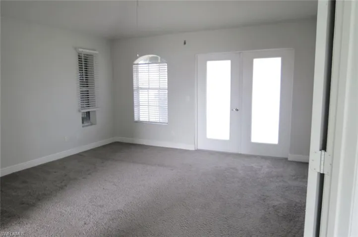 Unfurnished room with carpet flooring and french doors