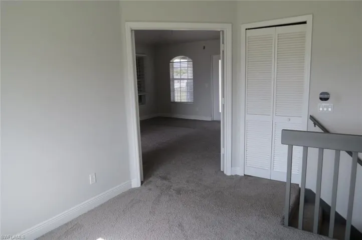 Corridor with light colored carpet