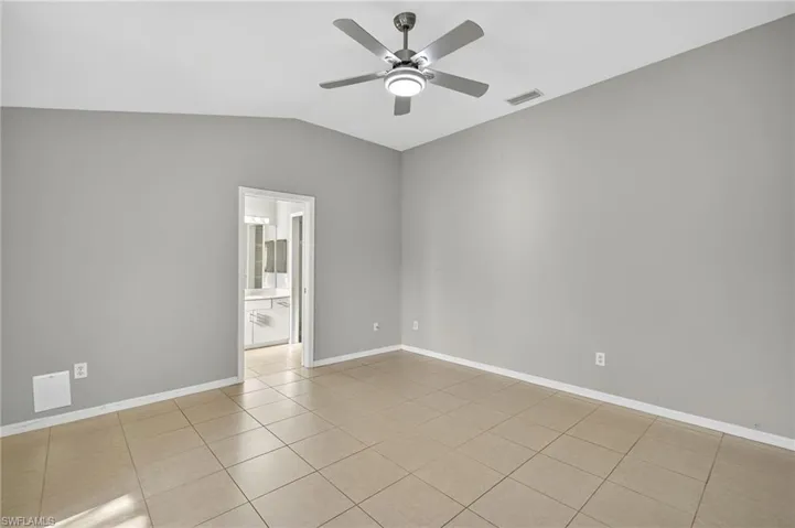 Unfurnished room featuring light tile patterned flooring, vaulted ceiling, and ceiling fan