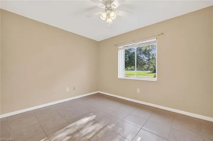 Empty room featuring light tile patterned floors and a ceiling fan