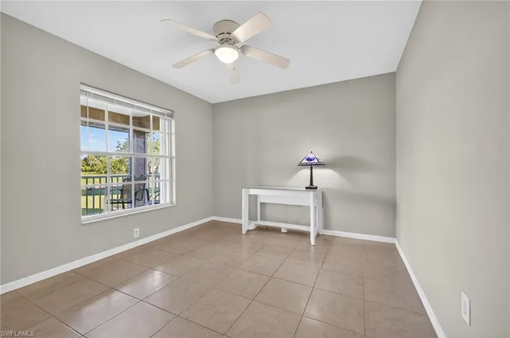 Empty room with light tile patterned floors and ceiling fan
