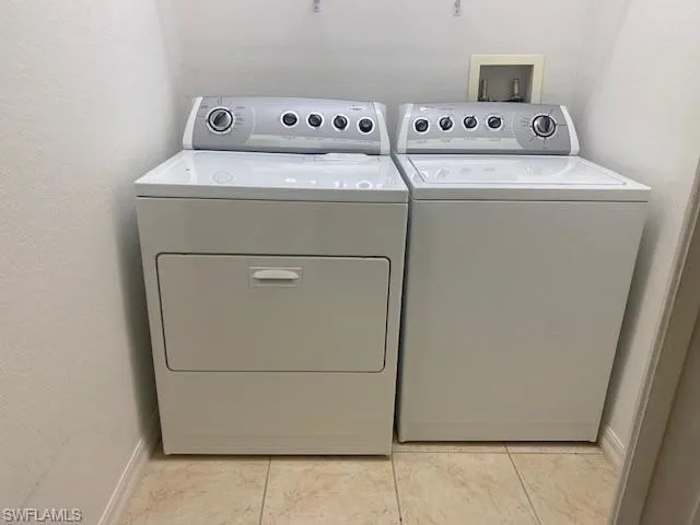 Laundry area with washing machine and dryer and a textured wall