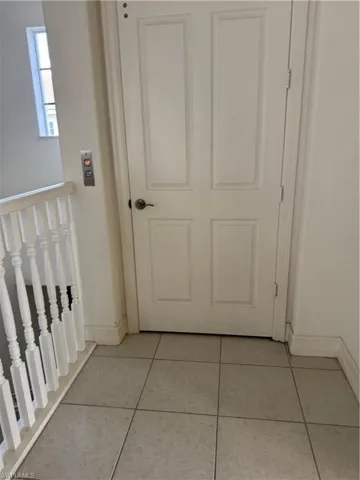 Corridor with light tile patterned flooring
