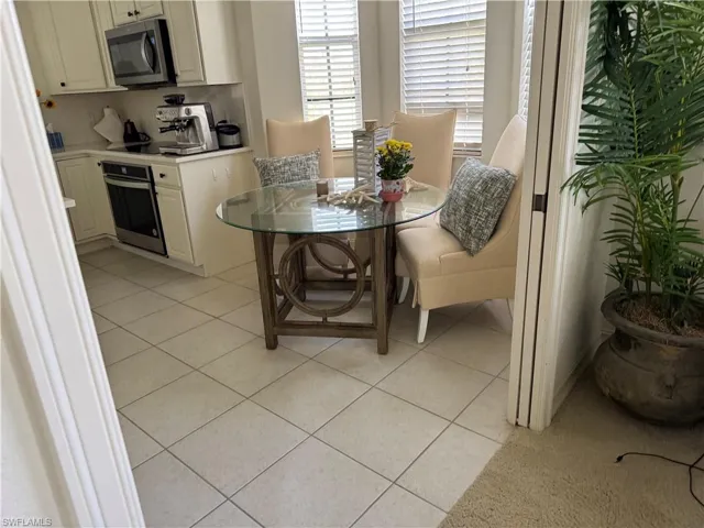 Dining space with light tile patterned flooring