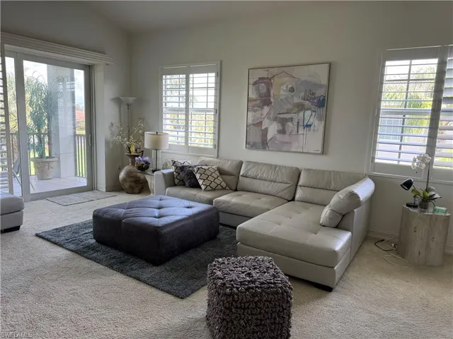 Living room featuring carpet and lofted ceiling