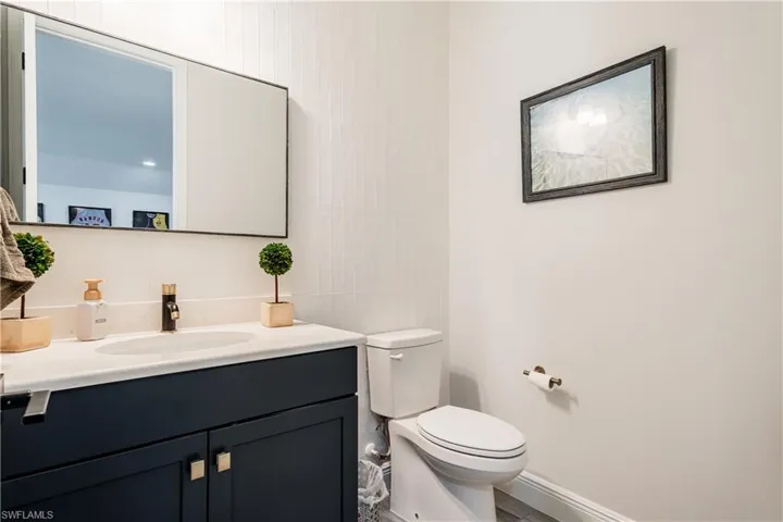 Half bathroom featuring vanity and tile walls