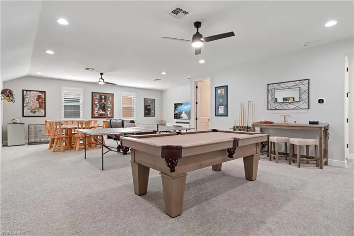 Recreation room with light colored carpet, recessed lighting, a ceiling fan, billiards table, and wet bar