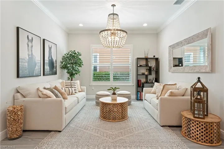 Living area featuring a chandelier, ornamental molding, recessed lighting, and wood finished floors