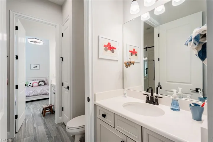 Ensuite bathroom with vanity, a shower stall, and dark wood-type flooring