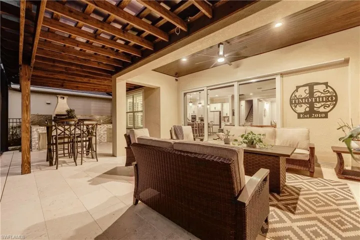 Living area featuring wood ceiling, a ceiling fan, and a textured wall