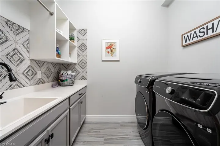 Laundry room featuring a sink and independent washer and dryer